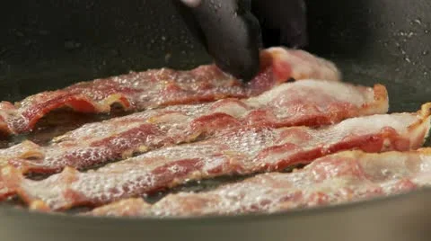 Rashers of bacon being fried in a pan Video stock 24635856