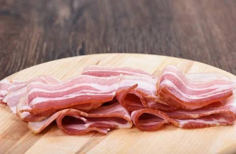 Rashers of bacon on a cutting board. Close up. Stock Photos
