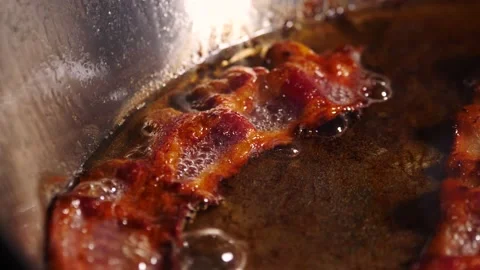 Rashers of crispy fatty bacon sizzling in hot oil Video stock 153753269