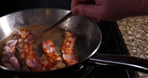 Rashers or slices of cured bacon frying in hot oil Video stock 153754953