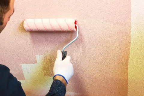 Rasit hand wall paint using a paint roller while working indoors Stock Photos