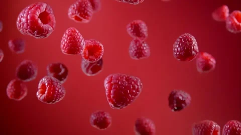 Raspberries are flying up and falling down on the red background in slow motion Stock Footage 287856355