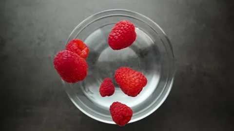 Raspberries fall into the water making splashes Stock Footage 262373138