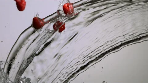 Raspberries falling and splashing into a stream of water Stock Footage 327632392