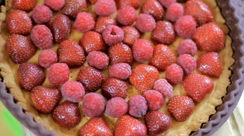 Raspberries falling on the fruit tart Stock Footage