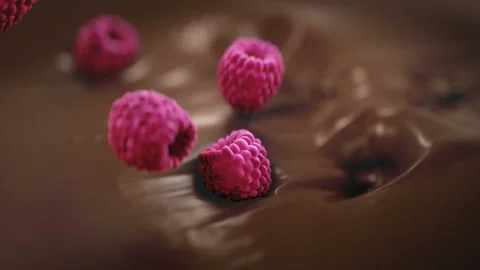 Raspberries Falling Into Liquid Chocolate in 4K Super slow motion Video stock 139911053