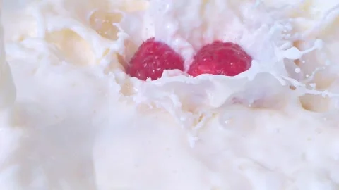 Raspberries falling into milk with splashes in slow motion 300fps Stock Footage 287998788