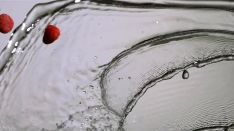 Raspberries falling into a splash of water Video stock 327052214
