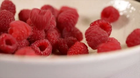 Raspberries Falling on a White Rotating Plate Closeup Stock Footage 99163050