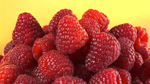 Raspberries isolated rotating on yellow background Video stock 62393662