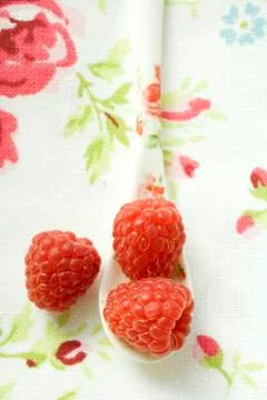 Raspberries on patterned spoon Stock Photos
