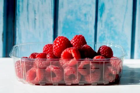 Raspberries in a plastic box Stock Photos