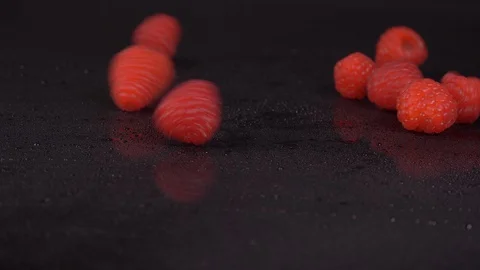 Raspberries Rolling into Frame in Slow-Motion over Black Background. Raspberries Stock Footage 127922608