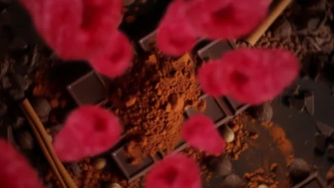 Raspberries spiraling and falling on a dark chocolate bar slow motion Stock Footage 258518933
