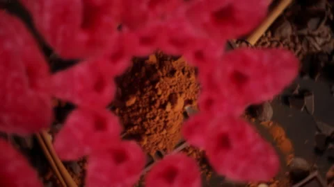Raspberries spiraling and falling on a dark chocolate bar slow motion Stock Footage 258519597