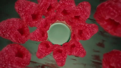Raspberries spiraling and falling down onto a plate on the table slow motion Stock Footage 258480981