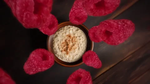 Raspberries spiraling and falling down into a cereal bowl slow motion Video stock 258481067