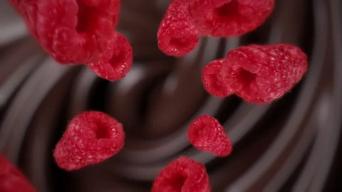 Raspberries spiraling and falling in the liquid chocolate slow motion Stock Footage 258510032