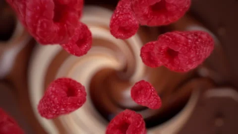 Raspberries spiraling and falling in the liquid milk chocolate slow motion Stock Footage 258510501