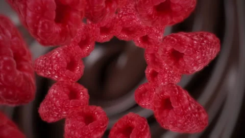 Raspberries spiraling and falling in the liquid dark chocolate slow motion Stock Footage 258512158