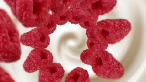 Raspberries spiraling and falling in the liquid milkshake slow motion Stock Footage 258514139
