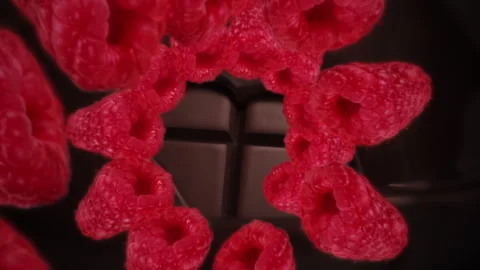 Raspberries spiraling and falling on a melting dark chocolate bar slow motion Stock Footage 258523895