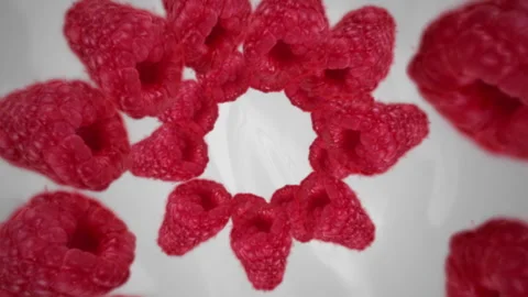 Raspberries spiraling and falling in the white milkshake slow motion Stock Footage 258479563