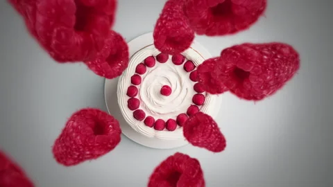 Raspberries spiraling and falling on a white cake slow motion Stock Footage 258520147