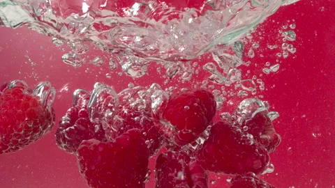 Raspberries Splash in Water on Red Background in Slow Motion Video stock 347658908