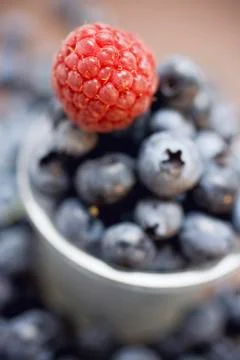 Raspberry and blueberries with plastic beaker Stock Photos