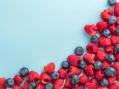 Raspberry and blueberry on blue background with copy space Foto stock
