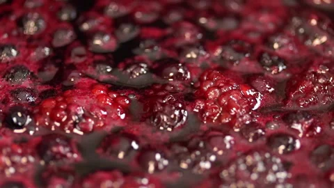 The raspberry and blueberry sauce is bubbling in the pot.  Stock Footage 141930199