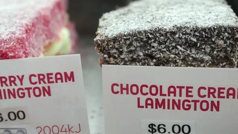 Raspberry and Chocolate Cream Lamingtons displayed for sale Stock Footage 336524367