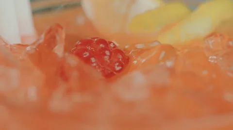 Raspberry and lemon rotating in a glass with ice Stock Footage 52193770