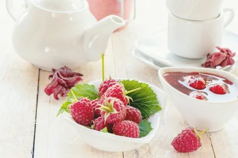 Raspberry and raspberry jam for tea in white dishes Stock Photos