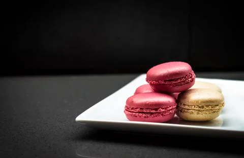 Raspberry and vanilla macaroons Dark background. Stock Photos