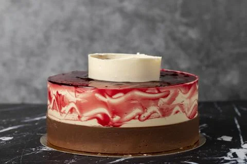 Raspberry and white chocolate cake. Cake with fruit and chocolate sauce on a  Stock Photos