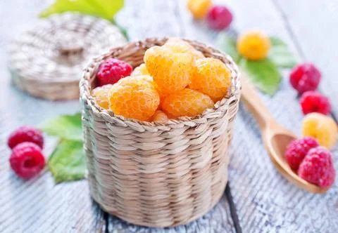 Raspberry in basket and on a table Stock Photos