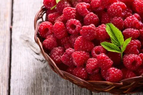Raspberry in a basket .on wooden background Stock Photos