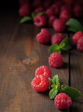 Raspberry berries and peppermint on a wooden table. Copy space. Stock Photos