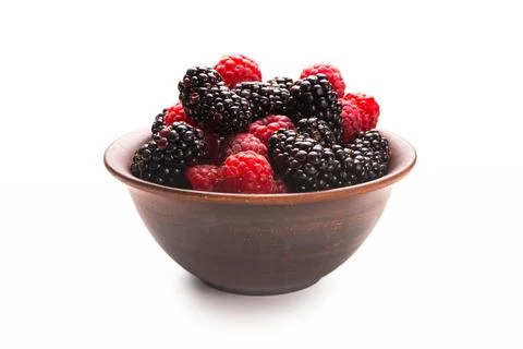 Raspberry, blackberry and mint leaf in ceramic brown bowl isolated on white Stock Photos