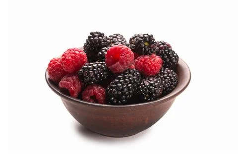 Raspberry, blackberry and mint leaf in ceramic brown bowl isolated on white Stock Photos