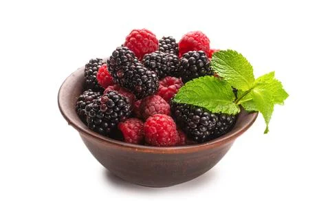 Raspberry, blackberry and mint leaf in ceramic brown bowl isolated on white Stock Photos