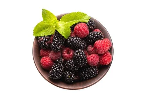 Raspberry, blackberry and mint leaf in ceramic brown bowl isolated on white Stock Photos