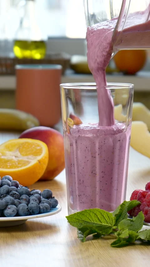 Raspberry Blueberry Melon Smoothie is poured into a glass on the background of Stock Footage 257097204