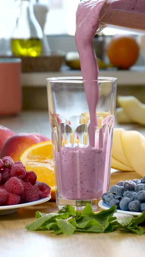 Raspberry Blueberry Melon Smoothie is poured into a glass on the background of Stock Footage 269369293