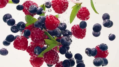 Raspberry, blueberry, mint leaves splash floating in the water, white background Stock Footage 156858883