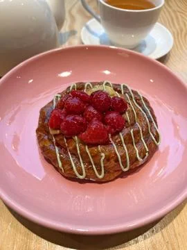 Raspberry bun for breakfast and black tea Stock Photos