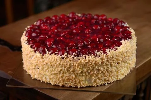 Raspberry cake with nuts on wooden table Stock Photos