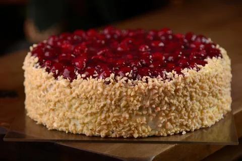 Raspberry cake with nuts on wooden table Stock Photos